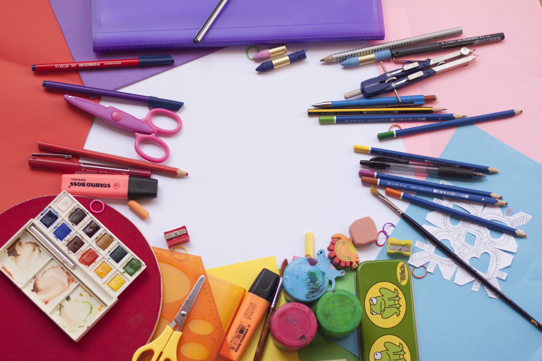Crayons, paper and scissors laid out on a table