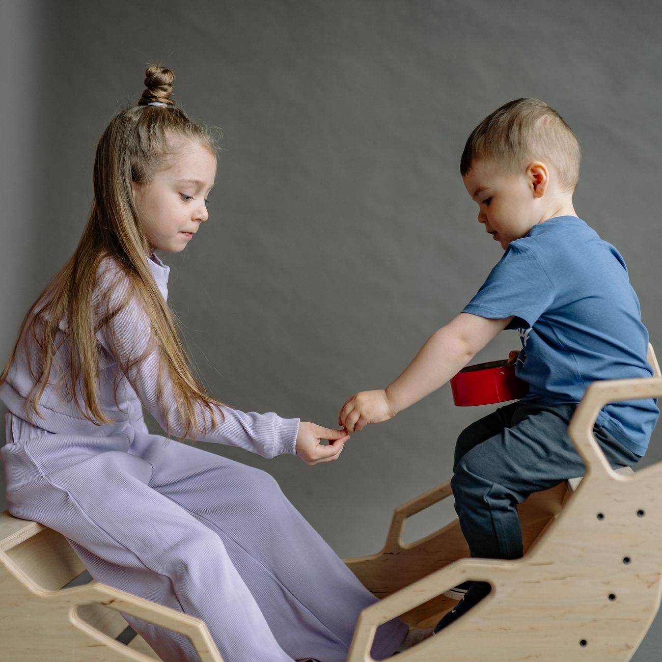 Toddlers playing with wooden toys in natural light